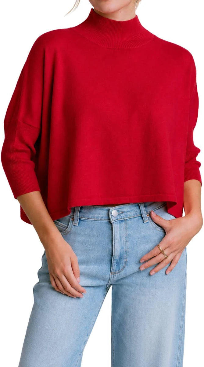 A person wearing a bright red cropped mock-neck knit sweater.